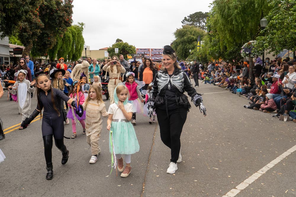 costume contest participants walk in parade
